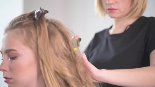 Close-up of a young girl with delicate makeup in a beauty salon. — Stock Video