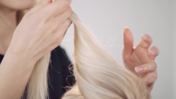 Блондинка працює тіммашером. Відокремлення ниток волосся . — стокове відео