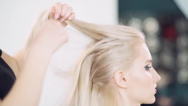 De kapper meisje scheidt de streng van haar en repareert de haarspeld. — Stockvideo