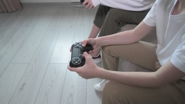 Broer en zus spelen met joysticks in hun handen. Joysticks dicht. — Stockvideo