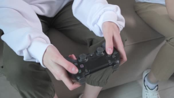 Fratello e sorella giocano con i joystick in mano. Joystick da vicino . — Video Stock