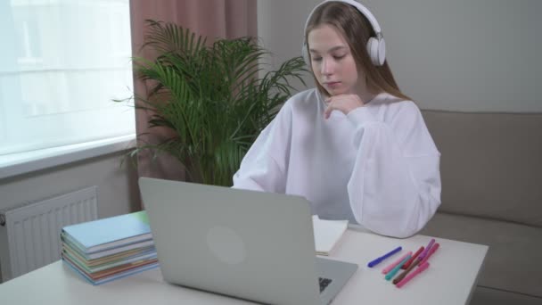 Menina está estudando cursos de língua estrangeira on-line com fones de ouvido . — Vídeo de Stock