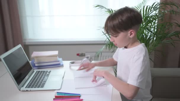 The guy is doing homework while sitting at the table. Sitting on the couch. — Stock Video