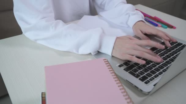 Chica escribiendo texto en un portátil. Clases en línea. Sobre la mesa hay libros. — Vídeos de Stock