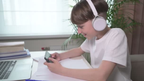 Wesoły chłopak odpoczywa po szkole i gra w gry przez telefon.. — Wideo stockowe