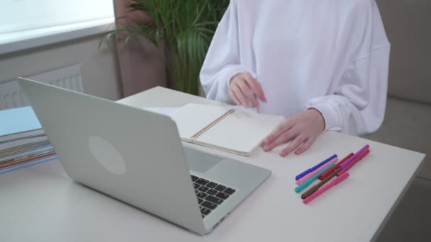 Ein junges Mädchen geht zur Schule und schreibt Informationen in ein Notizbuch. — Stockvideo