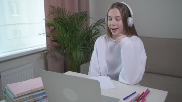 Happy Girl online beszél egy konferenciahíváson. A lány kiegyenesíti a haját — Stock videók