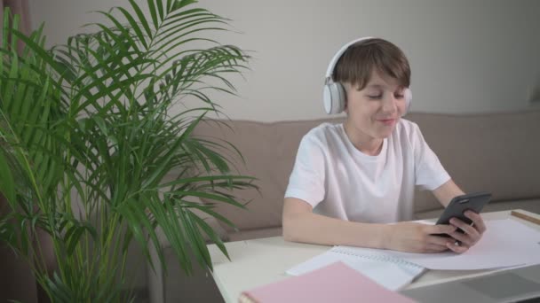 O menino está descansando da escola e jogando um laptop . — Vídeo de Stock