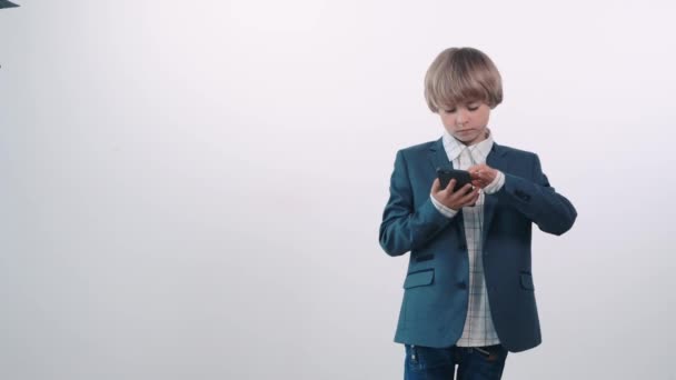 A handsome blond boy holds a cellphone in his hands and gets angry. — Stock Video