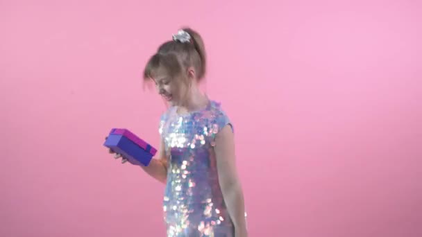 Belle fille mignonne dans une robe brillante reçoit des cadeaux pour son anniversaire . — Video