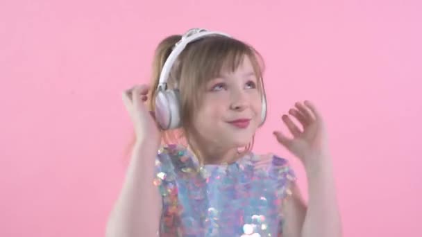 Крупным планом лицо девушки, ребенок слушает музыку в наушниках. Танцующий ребенок — стоковое видео
