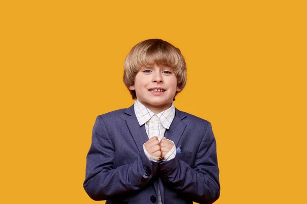 A boy with blond hair asks for something with his hands folded together — Stock Photo, Image