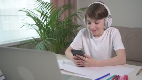 Веселый мальчик отдыхает от учебы и играет на ноутбуке . — стоковое видео