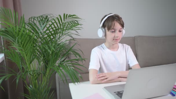 Pojken lyssnar på en online-föreläsning och visar en önskan att svara på en fråga. — Stockvideo