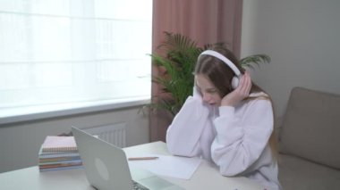 Genç bir kız çevrimiçi çalışmaktan ve çalışmaktan bıktı. Kulaklıklar kafaya..