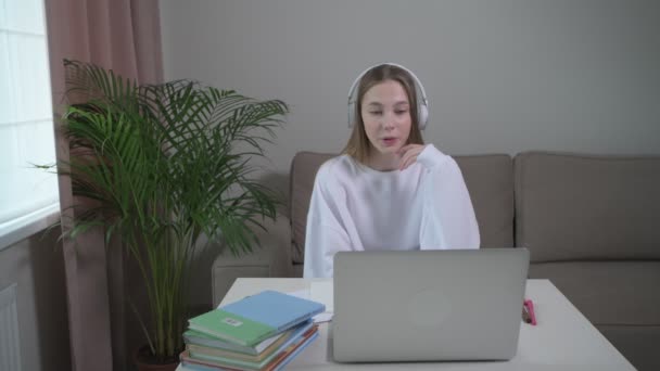 Fille étudie des cours de langue étrangère en ligne avec casque . — Video