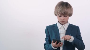 Ağzı açık yakışıklı sarışın çocuk elinde bir cep telefonu tutuyor..