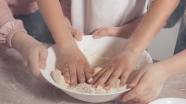Ağır çekimde çocuklar hamuru karıştırır. Çocuk elleri ve hamuru.