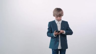 Zengin bir aileden gelen takım elbiseli güzel bir çocuk telefon kullanıyor..