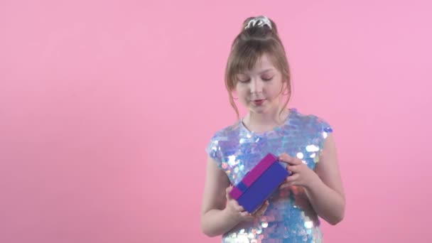 Gyönyörű aranyos lány kezében egy ajándék ünnepi csomagolásban. A lány ajándékot ad. — Stock videók
