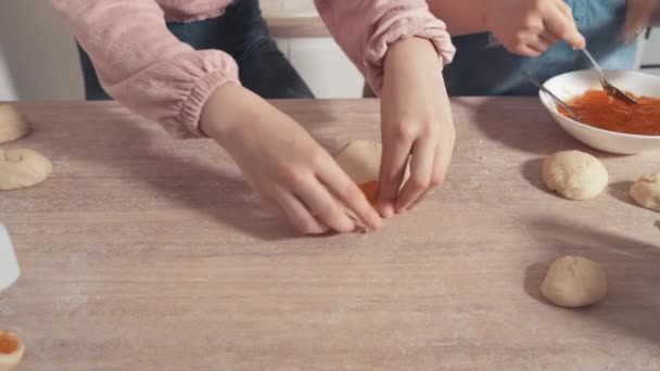 Children cook cookies with filling in the kitchen. Put the filling on the dough. — Stock Video