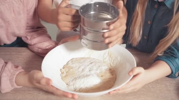 かわいい子供たちは生地を調理する方法を学びます。生地に小麦粉を追加.小麦粉をふるい分け — ストック動画