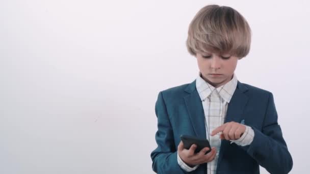 Surprised handsome blond boy with open mouth holds a cellphone in his hands. — Stock Video