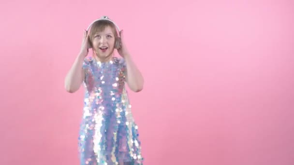 Belle fille heureuse écoute de la musique sur les écouteurs. Enfant dansant . — Video