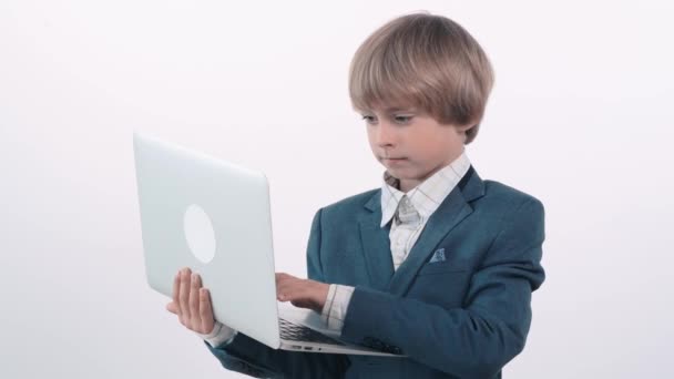 Un chico rubio lindo trabaja como freelancer. El niño es un hombre de negocios . — Vídeos de Stock