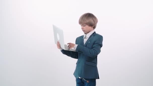 Serious little boy with laptop in his hands. Boy businessman. — Stock Video