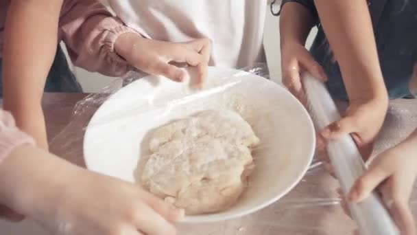 Primer plano cubrir la masa con película adhesiva. Los niños ayudan en la cocina . — Vídeo de stock