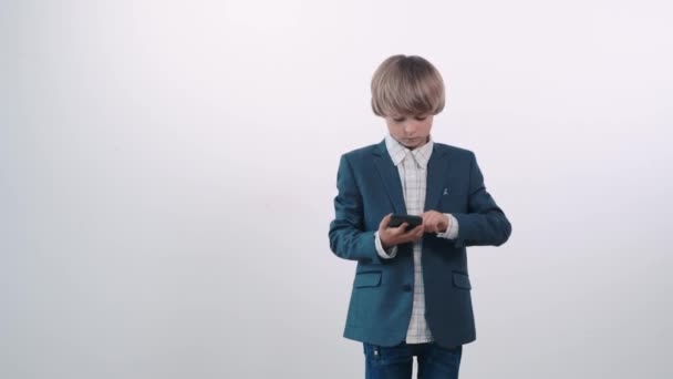 Un hermoso chico de una familia rica en un traje de negocios usa un teléfono . — Vídeos de Stock