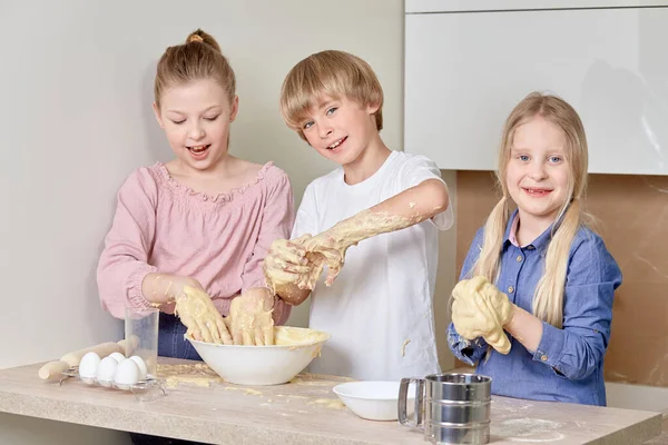 Cute beautiful children with blond hair are preparing cookies in the kitchen. — Stock Photo, Image