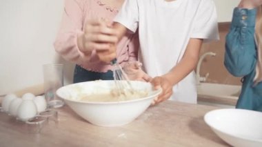 Hamuruna süzgeçten un ekle. Hamuru çırpıcıyla karıştır.