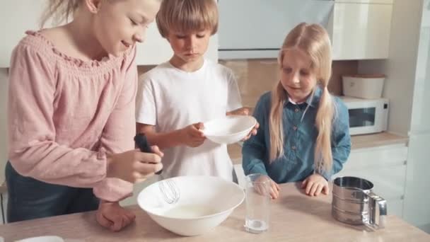 Barn tjänar pengar till kakor, pizza. Tillsätt socker i mjölken och blanda med en visp. — Stockvideo