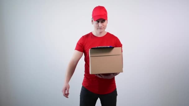 Хлопець з служби доставки в червоному комбінезоні вручає папір для підпису . — стокове відео