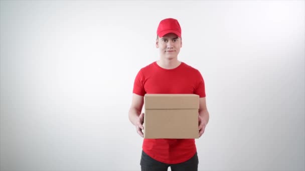 Een bezorger met een kartonnen pakje. Witte achtergrond. — Stockvideo