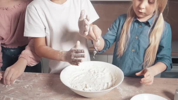 Lassú mozgás, liszt hozzáadása a tésztához. A gyerekek megtanulnak főzni. Fényes konyha. — Stock videók