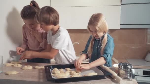 Mooie schattige blonde kinderen verschuiven het deeg voor het maken van koekjes. — Stockvideo