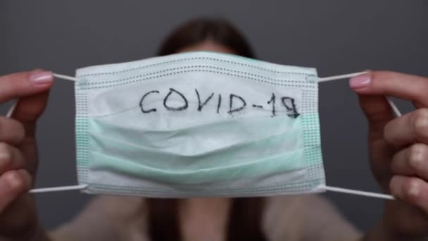 Жінка показує хірургічну маску для захисту Ковід19, коронавірус. — стокове відео