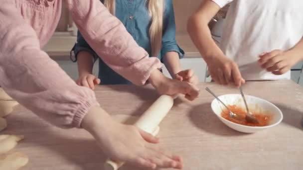Niedliche blonde Kinder bereiten Plätzchen mit Füllung in der Küche zu. — Stockvideo