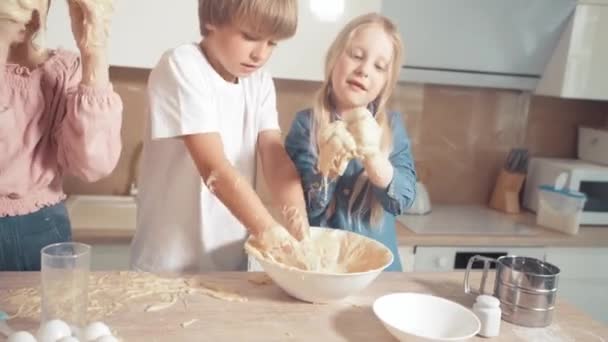 Kinderen leren om het deeg voor de taart te koken, meng het deeg met hun handen. — Stockvideo