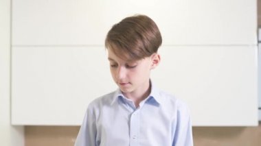 Güzel esmer çocuk, parlak bir mutfakta kendine kahvaltı hazırlıyor..