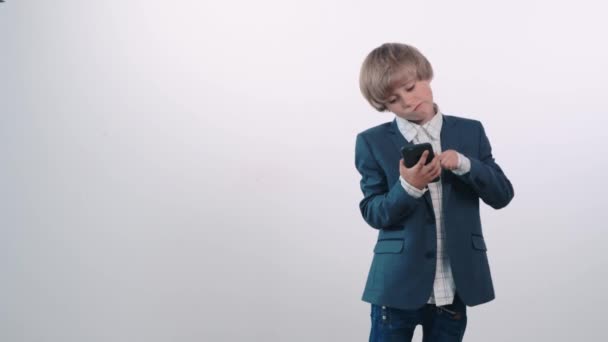 Beautiful blond boy with a mobile phone surprised by the victory and very happy. — Stock Video