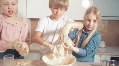 Çocuklar kurabiye pişirmeyi, hamuru elleriyle karıştırmayı öğrenirler. Yapışkan hamur.