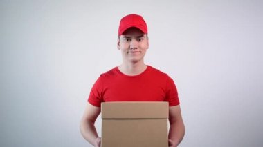 Elinde bir paket olan ve baş parmak hareketi yapan bir adamın yakın plan fotoğrafı..