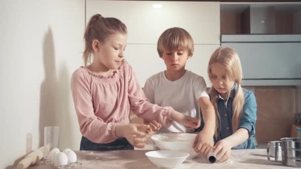料理におけるラップフィルムの使用。子供たちは台所で助けます. — ストック動画