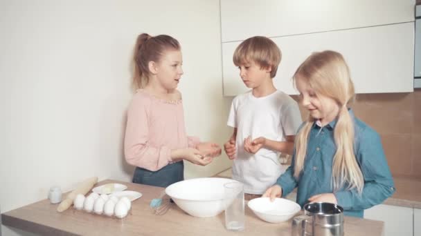 Kinder helfen Mama beim Kochen. Das Kind gießt Zucker in einen Teller mit Milch. — Stockvideo