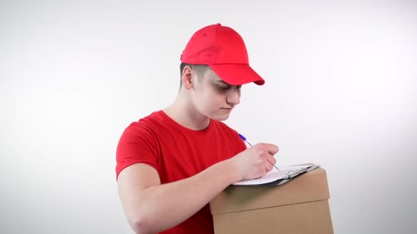 Pria tampan dari layanan pengiriman menandatangani dokumen yang mengkonfirmasi pengiriman. — Stok Video