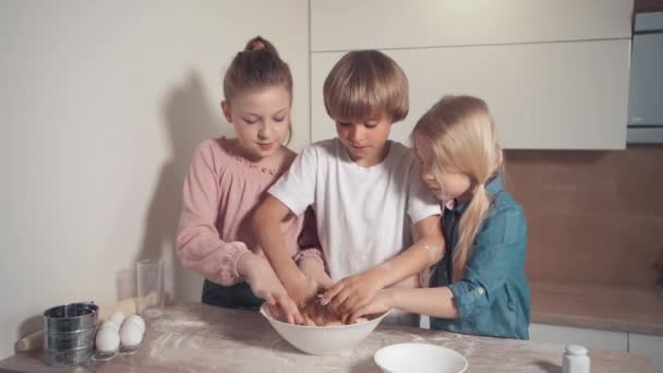 Les enfants blonds mignons préparent la pâte à tarte dans la cuisine. Cuisine lumineuse. — Video